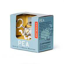 Load image into Gallery viewer, This image captures the light blue retail packaging for a Kikkerland mechanical wind-up toy named "Pea," featuring descriptive text written in both English and French. A large cutout window on the front reveals the intricate silver metal creature inside, highlighting its prominent winding key, exposed springs, and tiny white plastic feet.