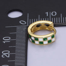 Load image into Gallery viewer, These small, green-and-white gold-toned huggie hoop earrings are lined up against a ruler and measure about 13 millimeters across.