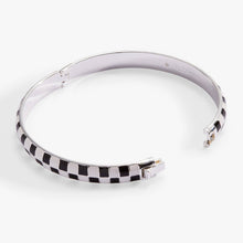 Load image into Gallery viewer, A silver hinged bangle bracelet by Alex and Ani shown in an open position, featuring a black-and-white enamel checkered pattern along its outer edge and an engraved logo on the inner smooth band.