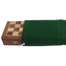 Load image into Gallery viewer, A folded wooden chessboard stored inside a dark green drawstring pouch.