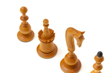 Load image into Gallery viewer, A close-up perspective of light-colored wooden chess pieces, including a knight carved as a horse head and a layered rook, angled against a plain white background.