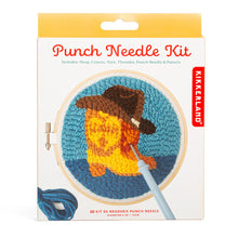 Load image into Gallery viewer, This retail box for a Kikkerland "Punch Needle Kit" features a playful Western theme and is topped with a solid yellow hanging tab. The clean white packaging prominently displays an illustration of a textured, completed project showcasing a yellow cowboy boot wearing a large brown cowboy hat, all set against a two-tone blue background and framed inside a six-inch wooden hoop.