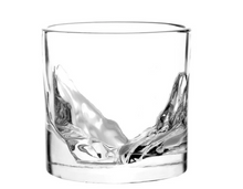 Load image into Gallery viewer, An empty, clear whiskey glass featuring a raised 3D glass mold of mountain peaks molded directly into the interior base.