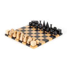 Load image into Gallery viewer, An angled view of a complete Man Ray design wooden chess set with geometric pieces positioned across the board.