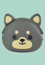 Load image into Gallery viewer, This is a small, round silicone coin purse shaped like a cute black-and-tan Shiba Inu dog's head, set against a solid mint green background. The pouch features a smooth, dark grey. face with simple minimalist details: simple black dot eyes, two light-cream circular eyebrow spots, and a prominent light-cream muzzle section with a black nose and a curved, smiling mouth. Two pointed ears extend from the top, each featuring light-cream triangular inner ear markings. it has a metal clasp.