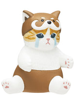 Load image into Gallery viewer, A ginger-and-white tabby cat figurine sitting on a white background, wearing a brown Shiba Inu costume with matching shorts. The cat has a sad expression with painted blue tears streaming from its large eyes, while the hood features pointy dog ears, white eyebrows, and a snout above its face.
