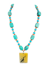 Load image into Gallery viewer, This Southwestern-style necklace features chunky, marbled turquoise nuggets interspersed with tiny orange coral beads, anchored by a rectangular yellow pendant showcasing a black lizard silhouette.