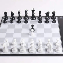 Load image into Gallery viewer, A straight-on view of the DGT Centaur electronic chessboard with black and white chess pieces positioned in starting rank formations on a grey and white grid