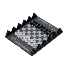 Load image into Gallery viewer, An angled overhead view of an unfolded black Venture Board mini travel chess set, displaying black and white circular pieces set up on its grey-and-black grid frame.