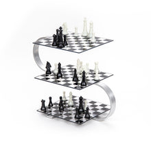 Load image into Gallery viewer, A full view of a three-level 3D chess set featuring black and white chess pieces arranged on tiered glass checkered boards connected by an S-shaped metallic frame against a white background.