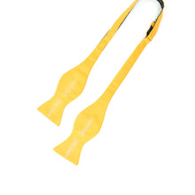 Load image into Gallery viewer, This is an untied bright yellow bow tie printed with an intricate, metallic silver design of ornate chess pieces extending down the center of each end.