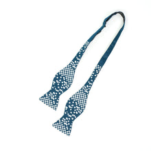 Load image into Gallery viewer, This is an untied dark teal bow tie printed with a white checkered pattern that gradually fragments into scattered pixel-like squares across the fabric.