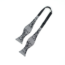 Load image into Gallery viewer, This is an untied black bow tie featuring a white checkered pattern along the paddle ends that transitions into scattered pixelated squares toward the neckband.