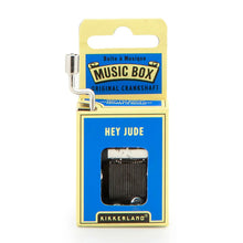 Load image into Gallery viewer, This image shows the same small, hand-cranked music box packaging, this time styled with a vibrant blue and pale yellow cardboard design. A silver metal crank extends from the top left side, and the front blue panel displays the text "HEY JUDE" right above the cutout window revealing the internal metal gears.
