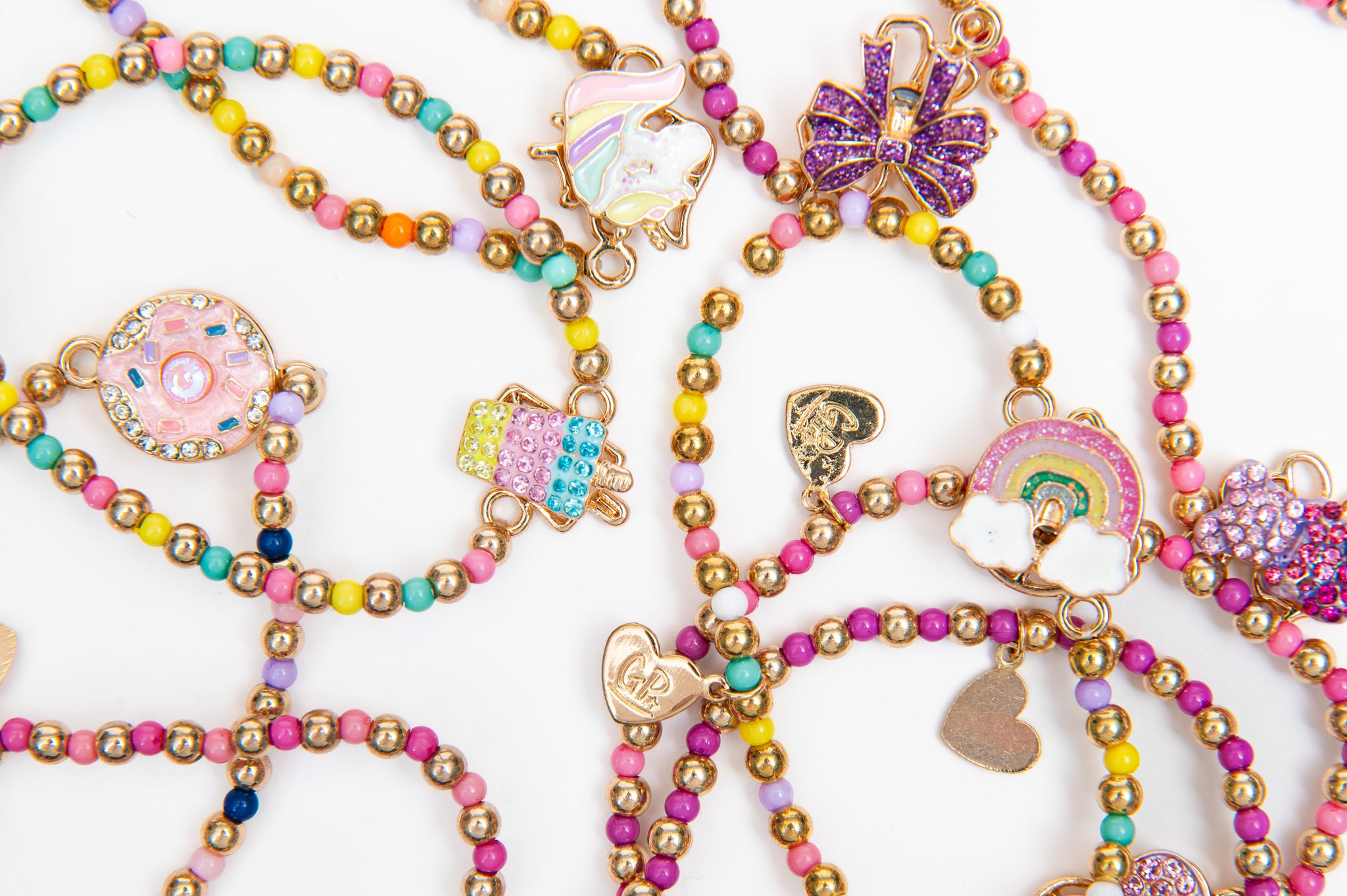 Load image into Gallery viewer, Assortment of Spinner Bracelets. Featuring whimsical charms like unicorns, rainbows, and sweets, these aren't just for looks—the center figures actually spin!