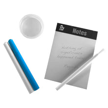 Load image into Gallery viewer, This image reveals the loose contents of the spy activity kit arranged on a plain white surface, featuring a small notepad with a decoy message alongside a shallow, clear plastic mixing dish. Next to the notepad rest two capped marker pens—one bright blue and one solid white—as well as a slender, all-white developer pen with a fine brush tip.
