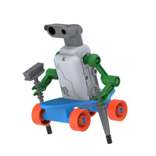 Load image into Gallery viewer, This image shows the completed "Halfpipe" skater robot standing assembled against a stark white background, balanced on top of a small, bright blue plastic skateboard with four orange wheels. Its boxy white body features a gray head with wide, black plastic eyes, and its vibrant green limbs grip a tiny gray toy broom in one hand and a gray umbrella handle in the other.
