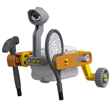 Load image into Gallery viewer, This image shows the assembled "Knox" walking robot against a plain white background, featuring a compact white motorized body and a high, periscope-like grey neck topped by a single large cartoon eye. Its sides are flanked by orange, wood-textured plastic panels holding a grey toy hammer and a tennis racket that act as front crutches, while bright yellow legs extend to the rear on two small, ridged grey wheels.
