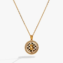 Load image into Gallery viewer, A gold fine-chain necklace featuring a round pendant with a crystal-halo frame and a spinning checkered center displaying a gold knight chess piece.

