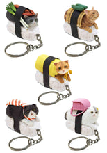 Load image into Gallery viewer, This image features five different keychains depicting realistic, miniature cats lying flat on beds of white sushi rice, each secured with a black seaweed band as if they are sushi toppings. The various cats—including a grey tabby, an orange tabby, and a fluffy white cat—are uniquely accessorized with playful food elements like green onions, cucumbers, a yellow egg blanket, or a tiny pink backpack.
