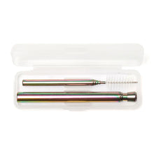 Load image into Gallery viewer, This image displays the iridescent travel straw set stored inside its open, frosted white plastic carrying case against a plain background. Inside the rectangular case, the collapsed rainbow-toned stainless steel straw lies horizontally along the bottom, while its matching, extendable cleaning brush rests neatly directly above it.
