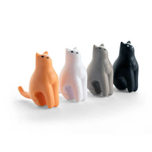 Load image into Gallery viewer, This image displays a neat row of four miniature, stylized plastic cat figurines standing side-by-side on a crisp white surface. Arranged from left to right in orange, white, grey, and black, each tiny cat features a hollowed underside designed to straddle a mug rim while tilting its head upward with simple dotted eyes.

