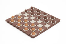 Load image into Gallery viewer, The flexible chessboard is repurposed for a game of checkers, set with light-brown and dark-brown acorn-shaped game pieces.
