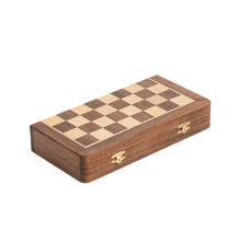 Load image into Gallery viewer, A closed rectangular wooden folding chessboard with brass latches and a checkered pattern on the top surface.
