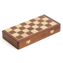 Load image into Gallery viewer, A closed, folded wooden chessboard with brass latches lies flat against a plain white background.
