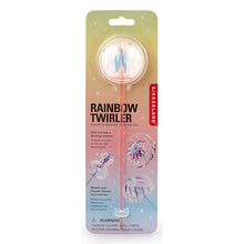 Load image into Gallery viewer, This retail blister pack for the Kikkerland "Rainbow Twirler" features a slender cardboard backing that blends softly from pastel green at the top to light pink and blue at the bottom. It holds a long, clear wand topped with a small, transparent plastic bubble enclosing fine iridescent ribbons that spin when operated.
