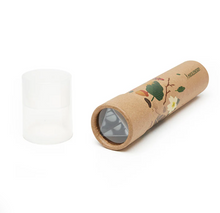 Load image into Gallery viewer, the unpackaged parts of the "Huckleberry Kaleidoscope" toy. It includes a decorated brown cardboard tube resting on its side to reveal a triangular arrangement of mirrors inside the lens opening, alongside its separate, standing cap made of semi-transparent clear plastic.
