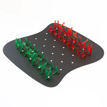 Load image into Gallery viewer, An angled view of an abstract chess set featuring translucent green and red acrylic geometric pieces set up on a curved black mat with grid dots.
