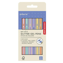 Load image into Gallery viewer, This image displays the retail packaging for Kikkerland's Inkerie "Set of 6 Glitter Gel Pens," presented on a cream-colored cardboard card with a purple, dotted top section and two cutout windows. Through the windows, you can see the six refillable pens featuring vibrant, multi-colored striped barrels in coordinating shades of pink, purple, turquoise, orange, yellow, and indigo.

