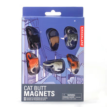 Load image into Gallery viewer,  retail packaging for "Cat Butt Magnets" presented in a blue cardboard box featuring a stylized cartoon background of a city street at night. Six distinct, three-dimensional plastic cat rear ends—including black, tabby, and calico patterns—are displayed through individual oval cutout windows.
