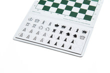 Load image into Gallery viewer, An angled close-up view of an open portable chess set showing flat, round magnetic chess pieces arranged below a green and white checkered board.   

