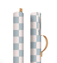 Load image into Gallery viewer, This image displays a roll of wrapping paper standing vertically against a solid white background, completely covered in a small, tight checkered pattern of sage-green and cream squares. The cylindrical roll showcases the pattern wrapped cleanly around its form, casting a soft shadow to its right.
