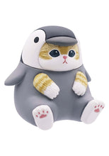 Load image into Gallery viewer, A small, round ginger-tabby cat figurine sitting against a plain white background, wearing a dark grey and white penguin suit. The penguin hood features a black beak over the cat's forehead, while tiny side flippers and white feet with pink paw pads complete the figurine. 
