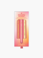 Load image into Gallery viewer, Presented in a rectangular, pink-to-orange gradient box, a set of three soft-touch gel pens arranged vertically inside a popsicle-shaped cutout. The pens come in muted pastel tones of coral, pink, and cream, with each barrel featuring a playful, capitalized phrase printed in a shiny gold font.
