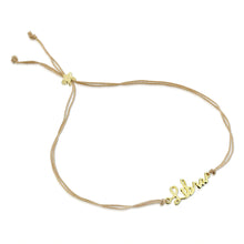 Load image into Gallery viewer, This image shows the unboxed "Libra" bracelet arranged in a loose loop against a plain white background. The delicate cursive gold nameplate rests at the bottom, while the double-strand tan cord threads through a tiny, metallic gold star-shaped slider at the top to adjust the fit.
