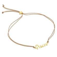 Load image into Gallery viewer, This image shows the unboxed "Pisces" bracelet arranged in a loose loop against a plain white background. The delicate cursive gold nameplate rests at the bottom, while the double-strand tan cord threads through a tiny, metallic gold star-shaped slider at the top to adjust the fit.
