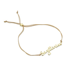 Load image into Gallery viewer, This image shows the unboxed "Sagittarius" bracelet arranged in a loose loop against a plain white background. The delicate cursive gold nameplate rests at the bottom, while the double-strand tan cord threads through a tiny, metallic gold star-shaped slider at the top to adjust the fit.
