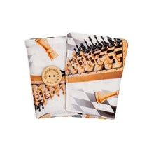 Load image into Gallery viewer, handmade chess themed coffee cozy with wooden button that shows chess pieces set up on a chess board
