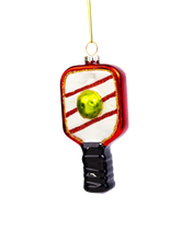 Load image into Gallery viewer, A red-framed pickleball paddle glass ornament featuring white and red diagonal stripes and a bright yellow ball fixed to the face.
