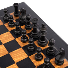Load image into Gallery viewer, A close-up, angled view of matte black wooden chess pieces arranged on an olive wood and black board.
