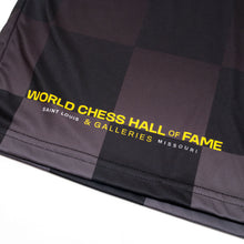 Load image into Gallery viewer, This close-up photo shows the bottom hem featuring a subtle dark gray checkered pattern. Printed in bold yellow and white text near the corner are the words "WORLD CHESS HALL OF FAME" above " &amp; GALLERIES SAINT LOUIS,MISSOURI".
