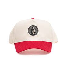Load image into Gallery viewer, A two-tone baseball cap with an off-white crown and a contrasting red brim paired with a matching red top button. Centered on the front panel is a circular black patch featuring a white king chess piece icon encircled by the text "WORLD CHESS HALL OF FAME &amp; GALLERIES SAINT LOUIS, MISSOURI".
