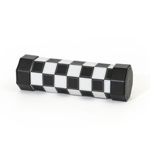 Load image into Gallery viewer, A compact, rollable travel chessboard made of black and white stitched leather rolled tightly into an octagonal tube with solid black end caps.
