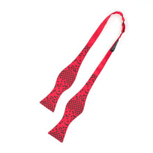 Load image into Gallery viewer, This is an untied bright red bow tie displaying a black checkered grid on the wide ends that disperses into scattered square pixels.
