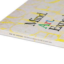 Load image into Gallery viewer, An angled close-up of the book's spine and cover corner, highlighting the title "Mind. Art. Experience." in dark serif typography over a yellow pattern.
